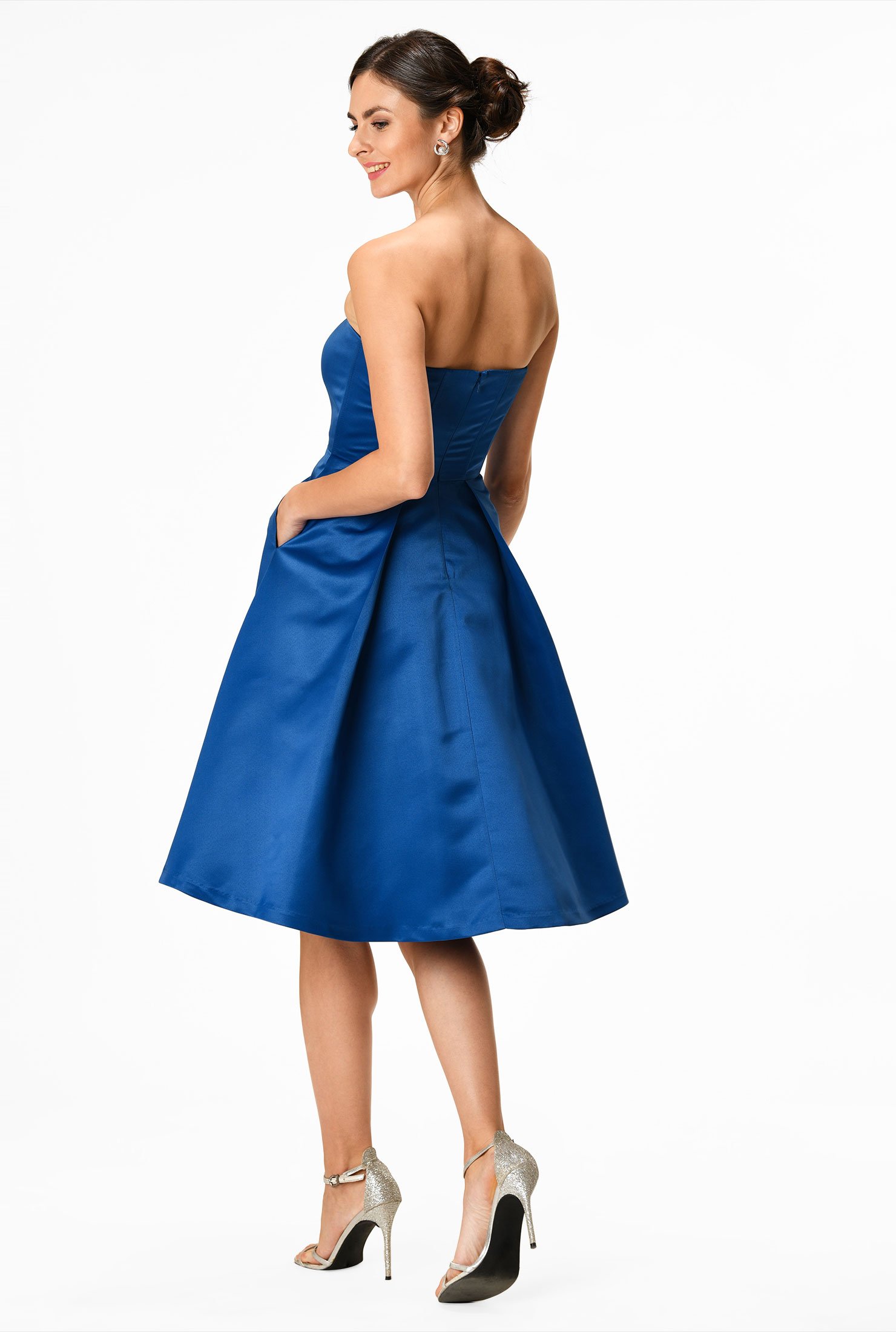 Our polydupioni dress is styled with a strapless bodice and flared out to a full skirt with asymmetric angled pleats.