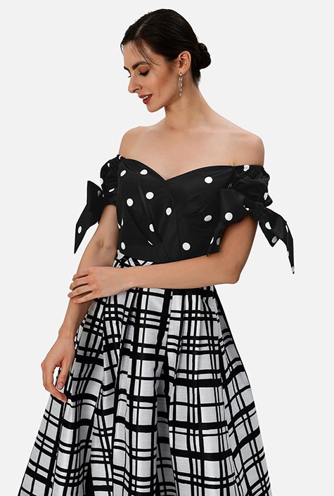 Bow-tie puff sleeves frame our mixed print dress with a flirty off-the-shoulder neckline that accentuates the silky shine and old-world glamour of our satin and dupioni dress. 