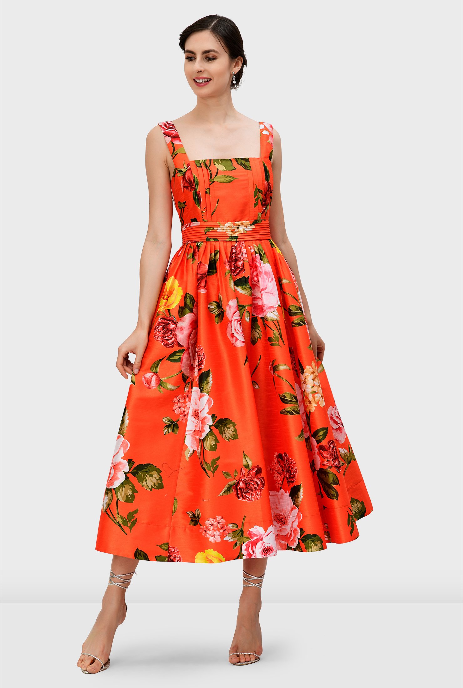 Over-blown bloom print patterns our polydupioni dress in a vibrant hue featuring a fitted bodice and knife pleat full skirt while a pleated waist cinches in the flattering silhouette.