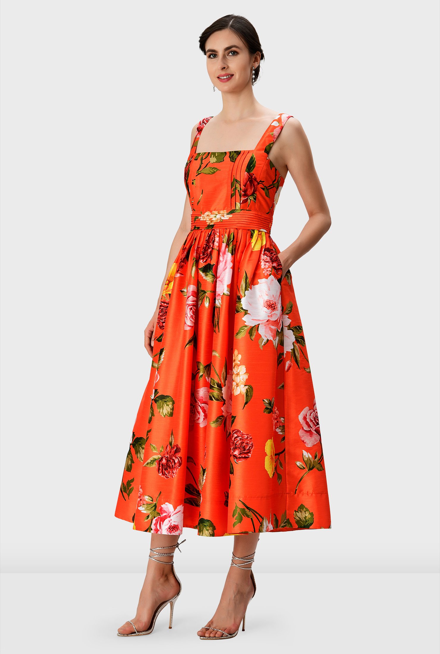Over-blown bloom print patterns our polydupioni dress in a vibrant hue featuring a fitted bodice and knife pleat full skirt while a pleated waist cinches in the flattering silhouette.