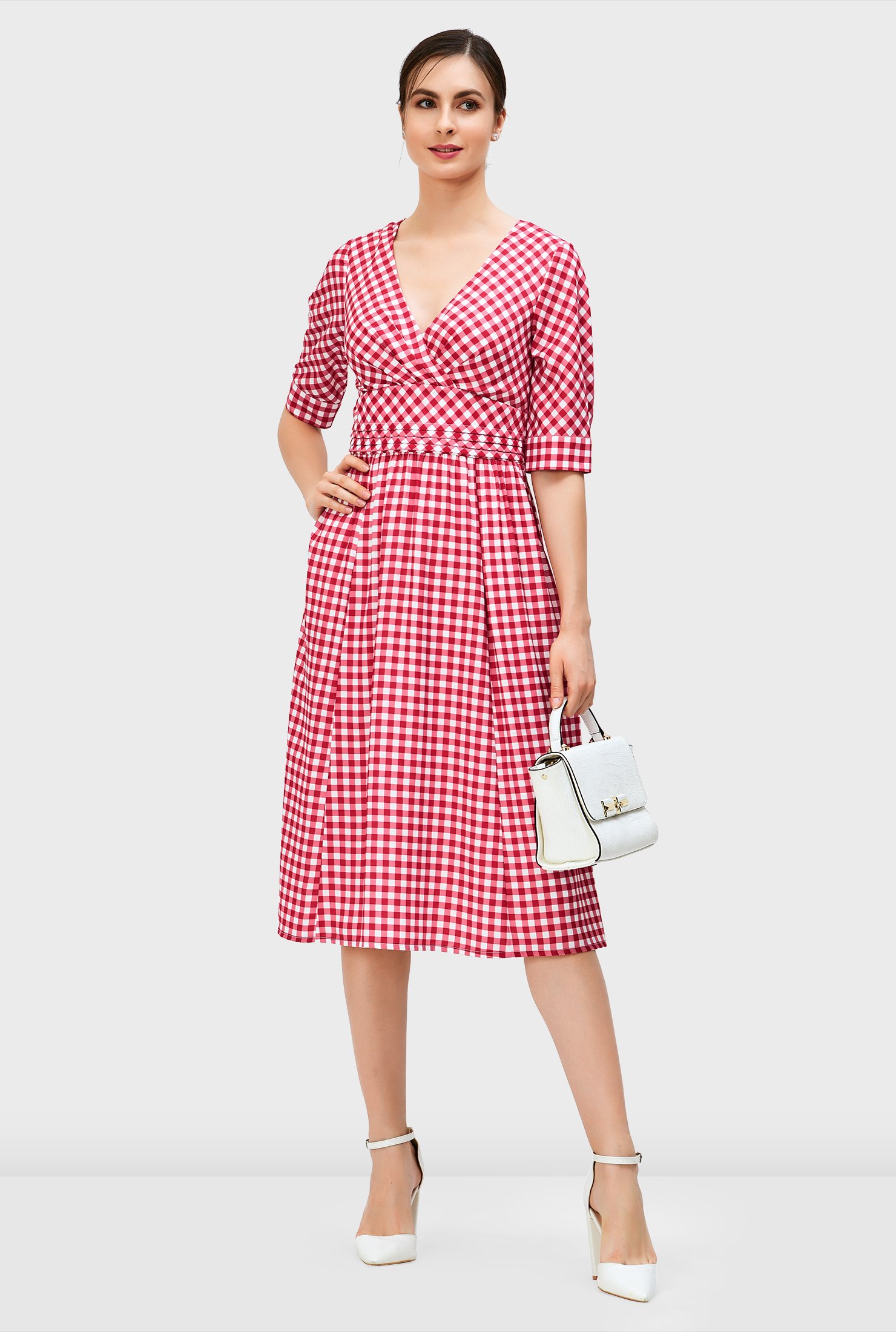 The summer dress refresh! Our gingham check print crepe dress is styled with a surplice bodice and pleated empire waist that flares out to a ruched pleat full skirt.