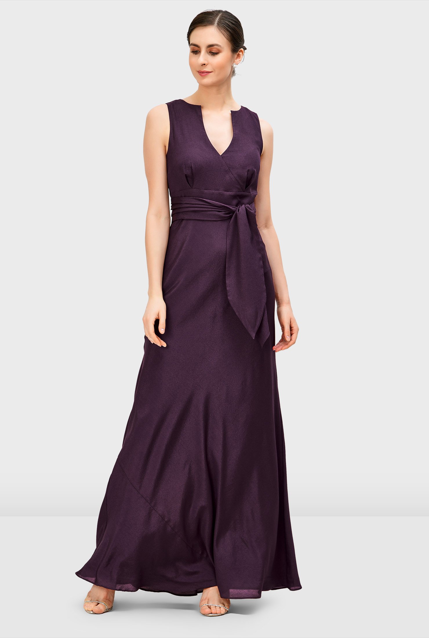 Earn the title of best-dressed wedding guest in our elegant crepe dress styled with a surplice bodice, empire waist and floor-length full flare skirt.
