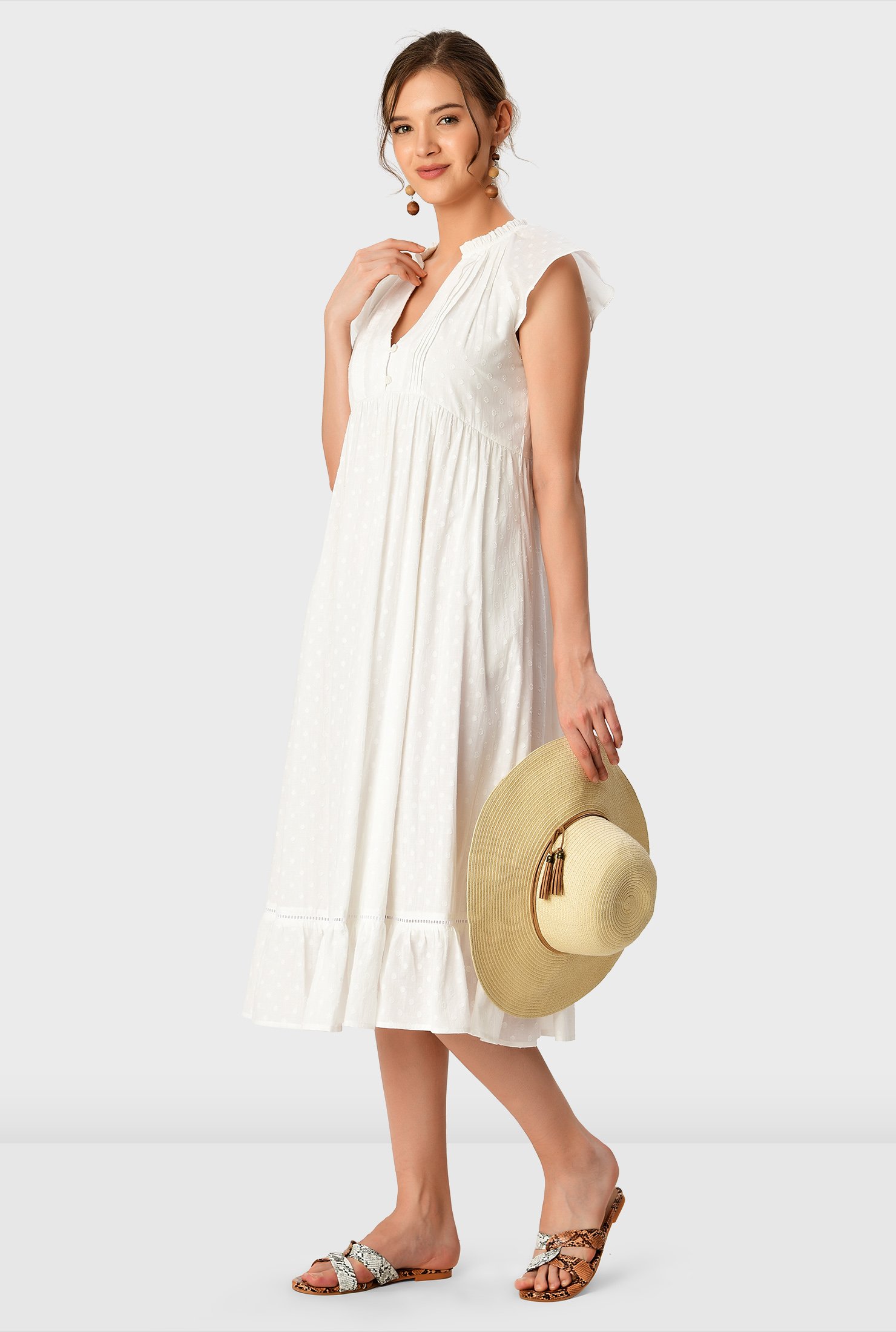 The perfect summer dress, our weightless white crafted from swiss dot cotton voile with a short rouleau-button front and relaxed empire waist floats down to a ruffle flounce hem.