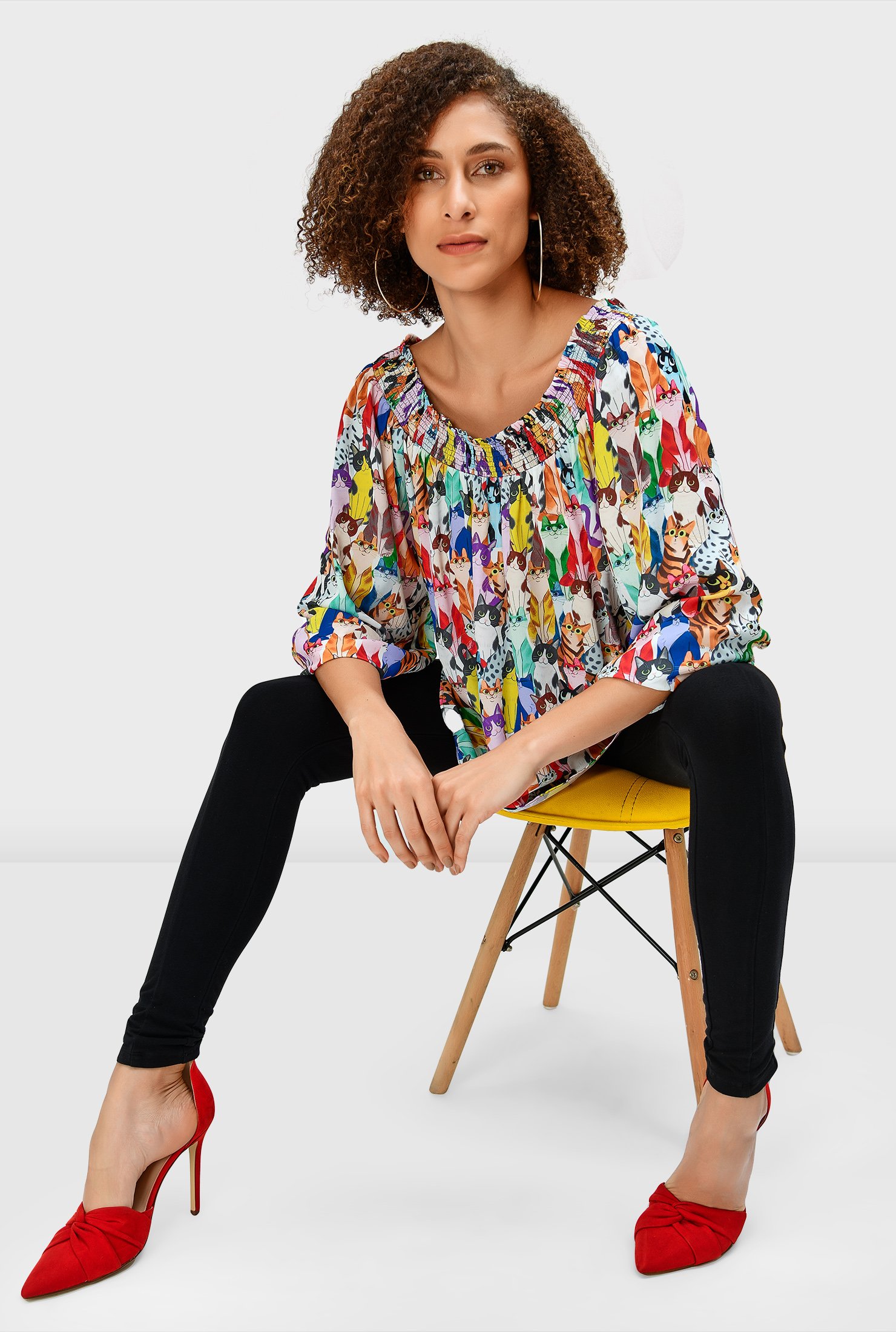 Colorful allover cats brighten our blousy top styled with an elastic-smocked neckline and puffed sleeves.