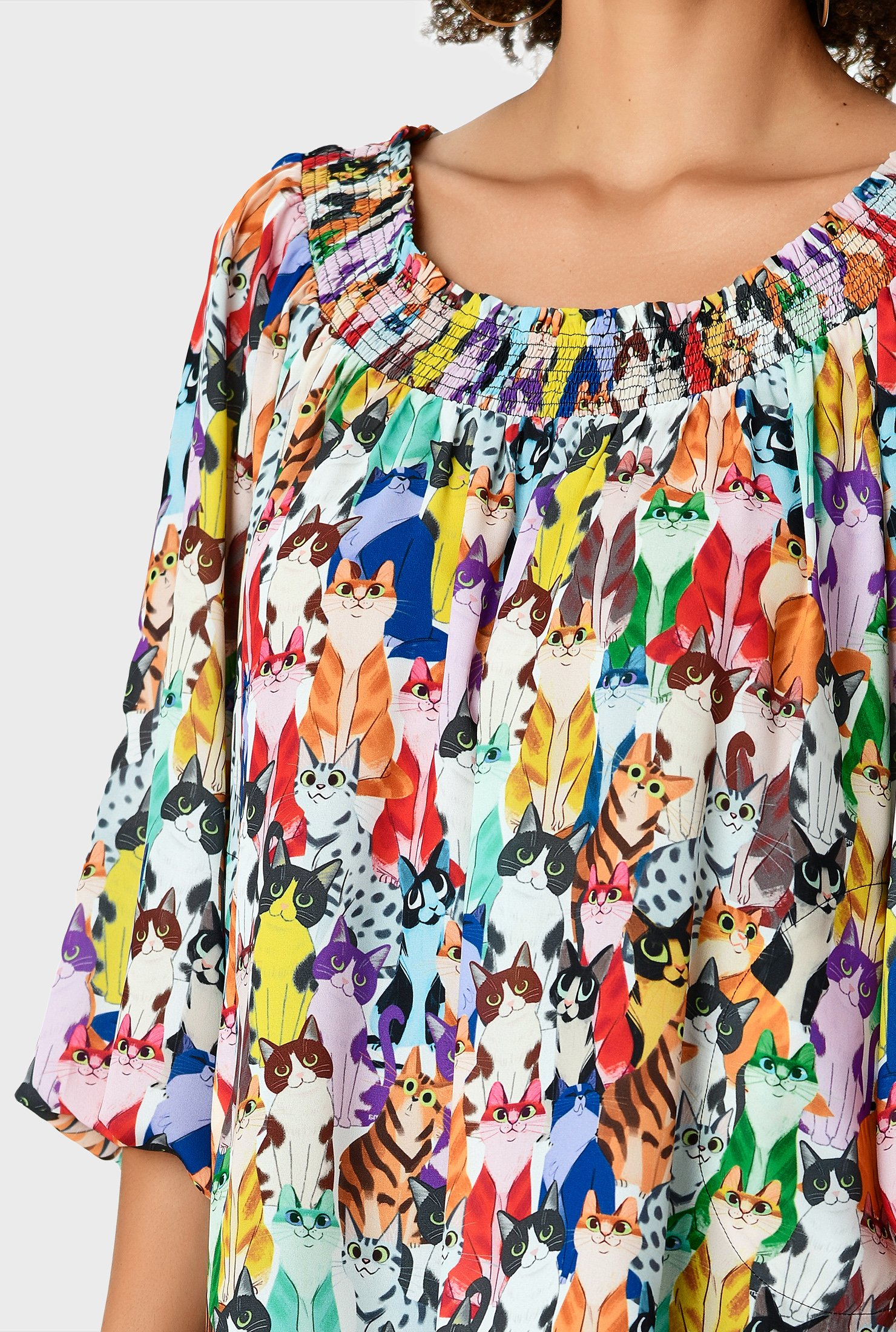 Colorful allover cats brighten our blousy top styled with an elastic-smocked neckline and puffed sleeves.