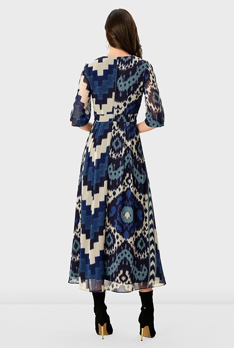 A surplice bodice drapes the top of our ikat print georgette dress styled with an empire waist and flared at the full skirt. 